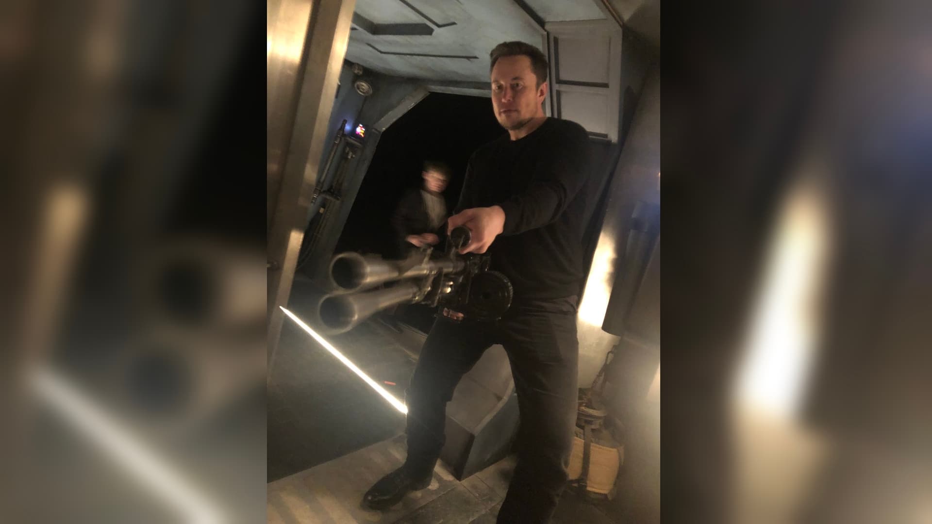 Elon Musk Holding a Minigun meme template - Elon Musk Minigun
