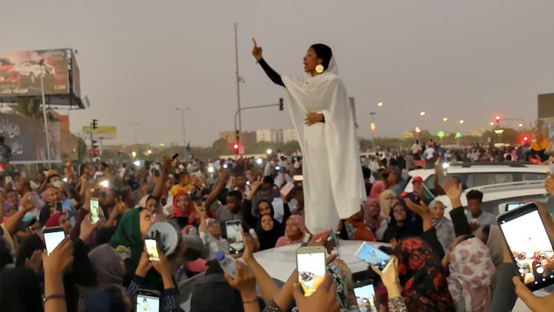 Protesting Sudanese Woman Standing on Car meme template - Sudanese Woman Standing on Car